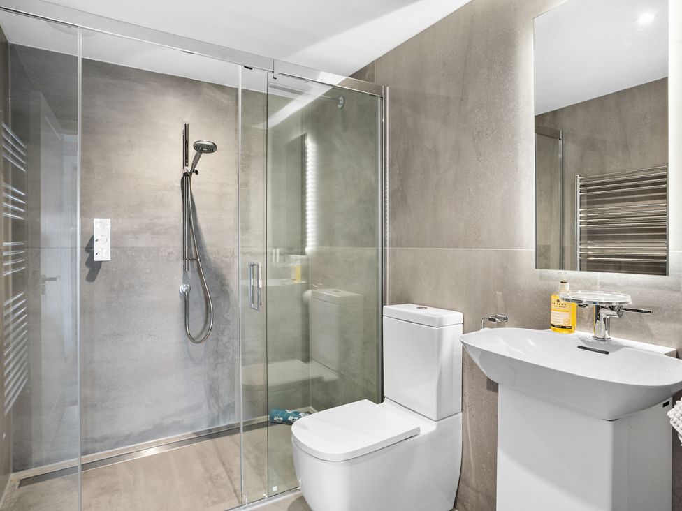 A bathroom with a glass shower enclosure toilet and sink at Huxham View and Annex in Stoke Canon